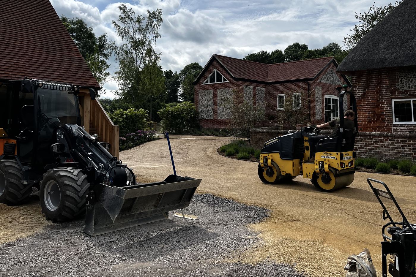 Telehandler and roller working a driveway construction job