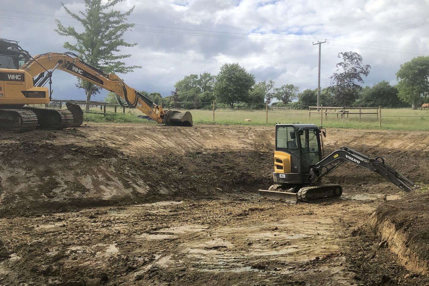 Excavators forming a reduced level dig and drainage basin