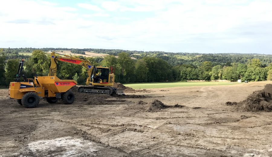 Excavator and dumper stripping and levelling a site